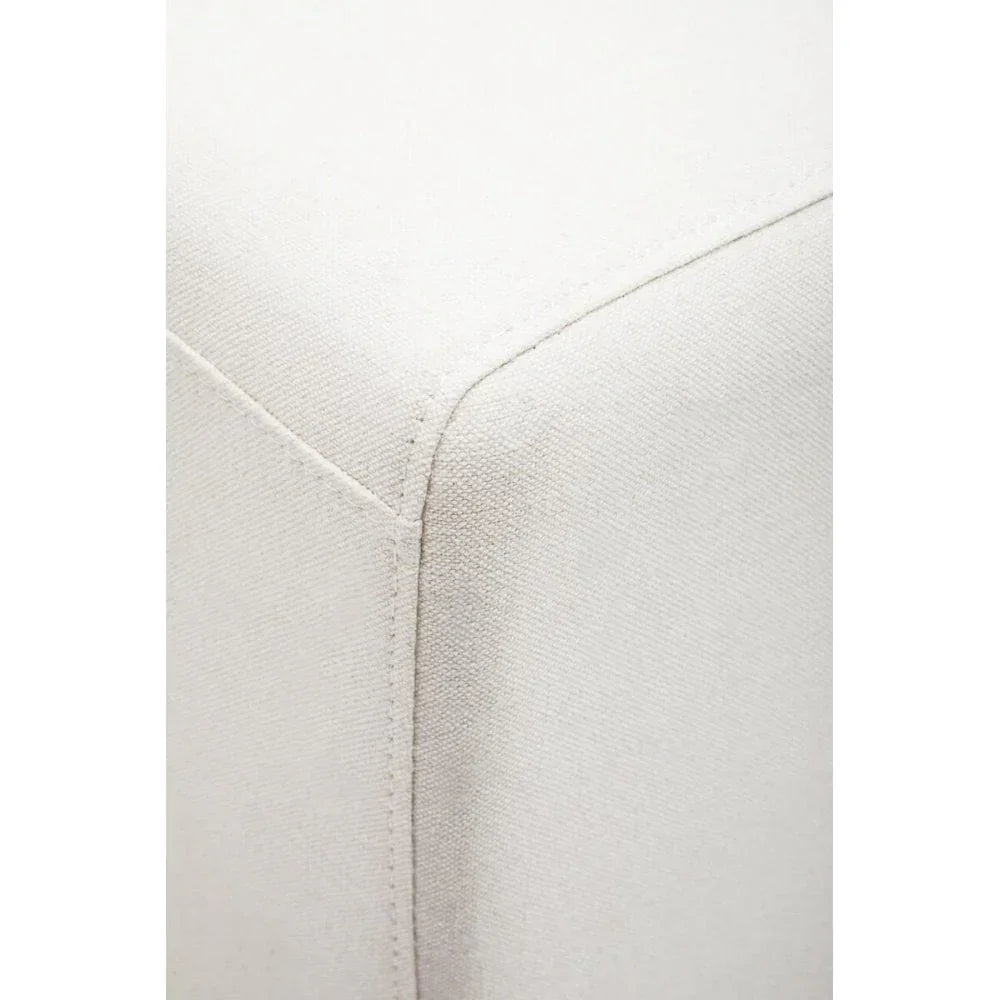 Closeup of cream fabric ottoman corner with visible stitching detail