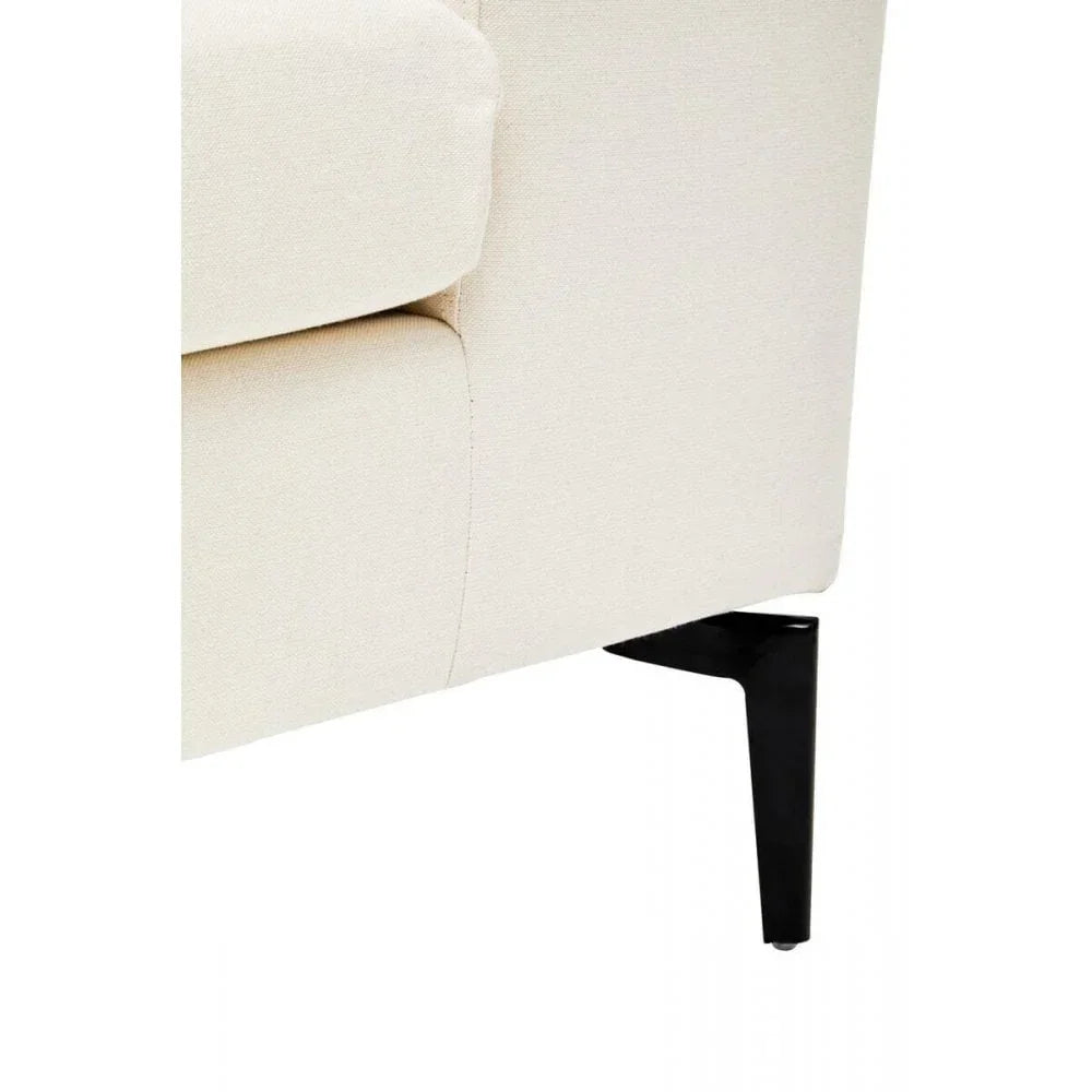 Cream fabric sofa corner with black metal leg, close-up on cushion and frame details