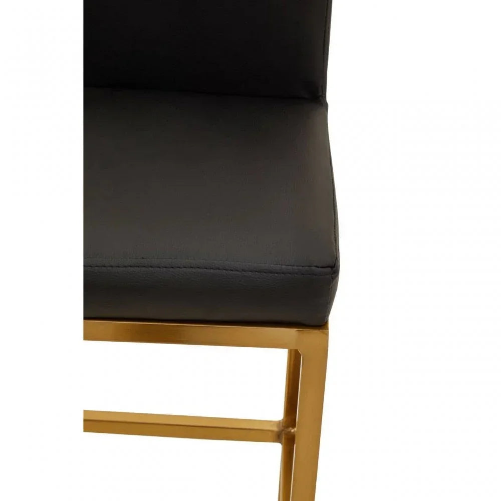 Black leather dining chair seat with gold metal frame close-up