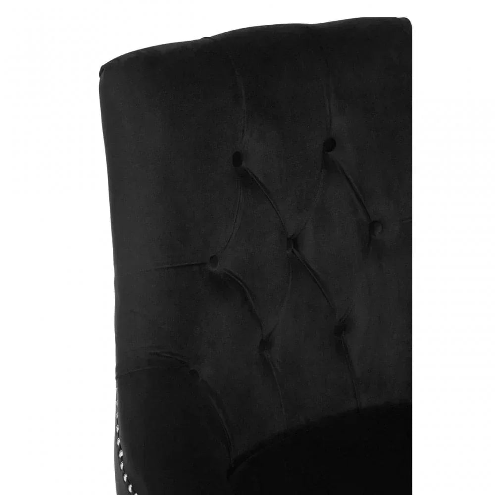 Close up of black velvet dining chair with deep button tufted backrest