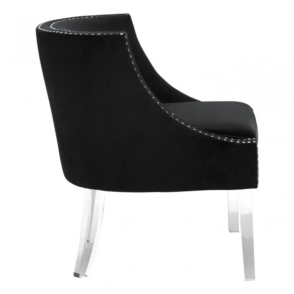 Black velvet accent chair with curved backrest and clear acrylic legs, side profile view