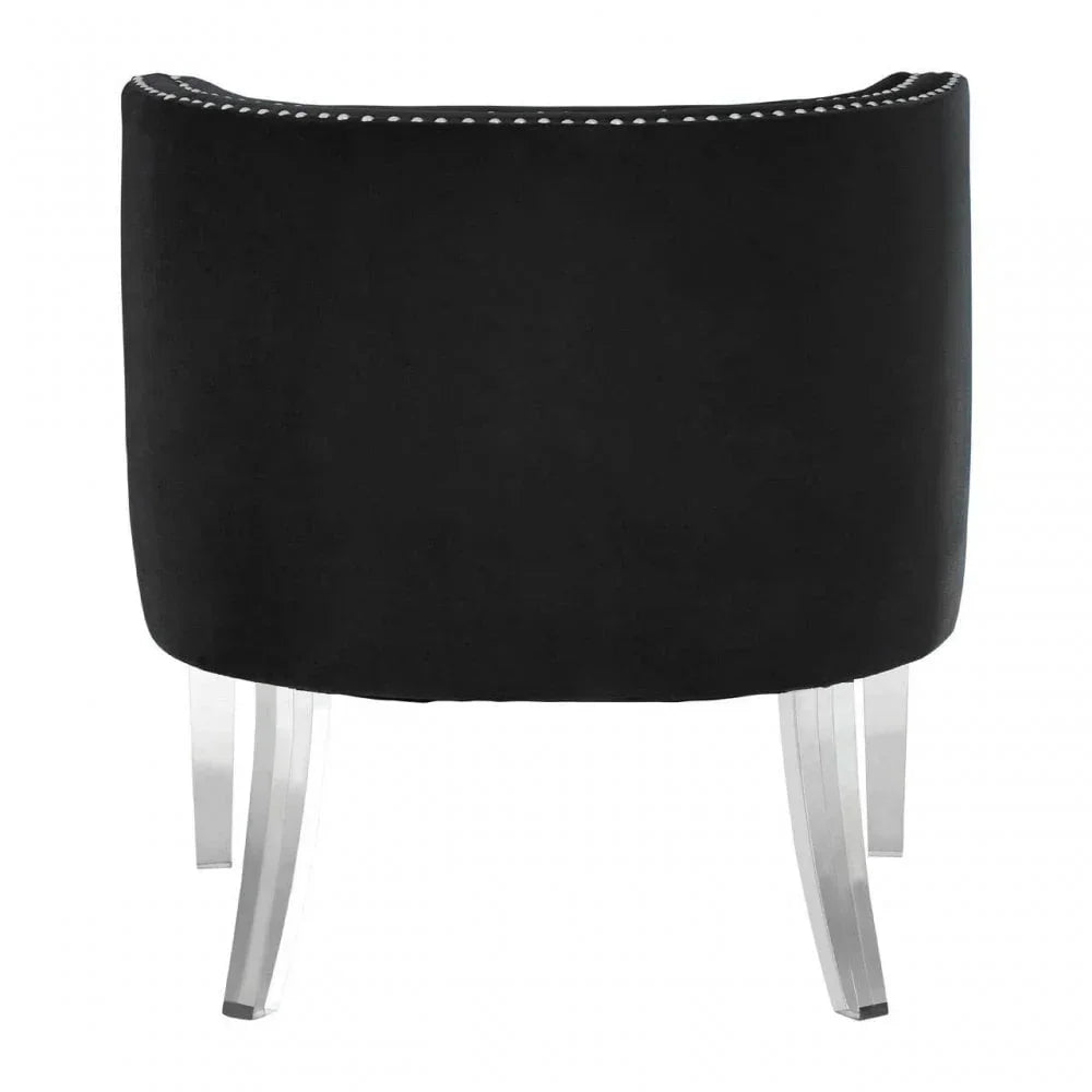 Black velvet accent chair with curved back and chrome legs, rear view