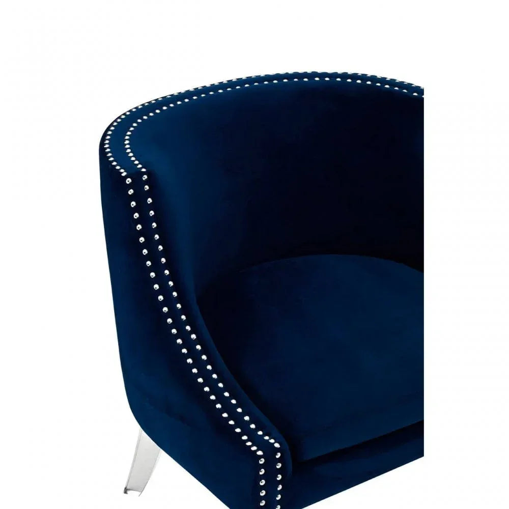 Navy velvet armchair with silver stud detailing and curved backrest