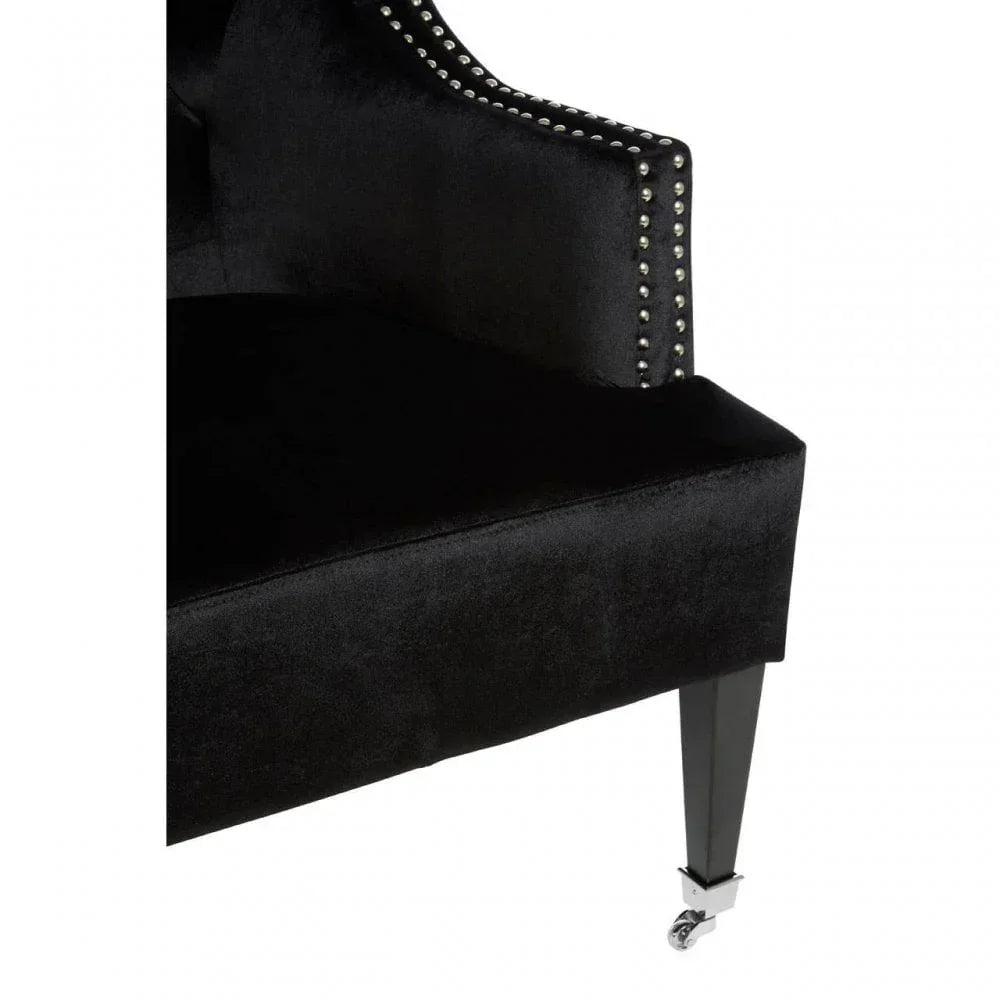 Black velvet chair with studded trim and caster leg detail