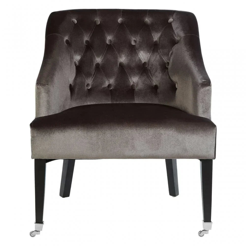 Velvet accent chair with button-tufted backrest and dark wooden legs, front view
