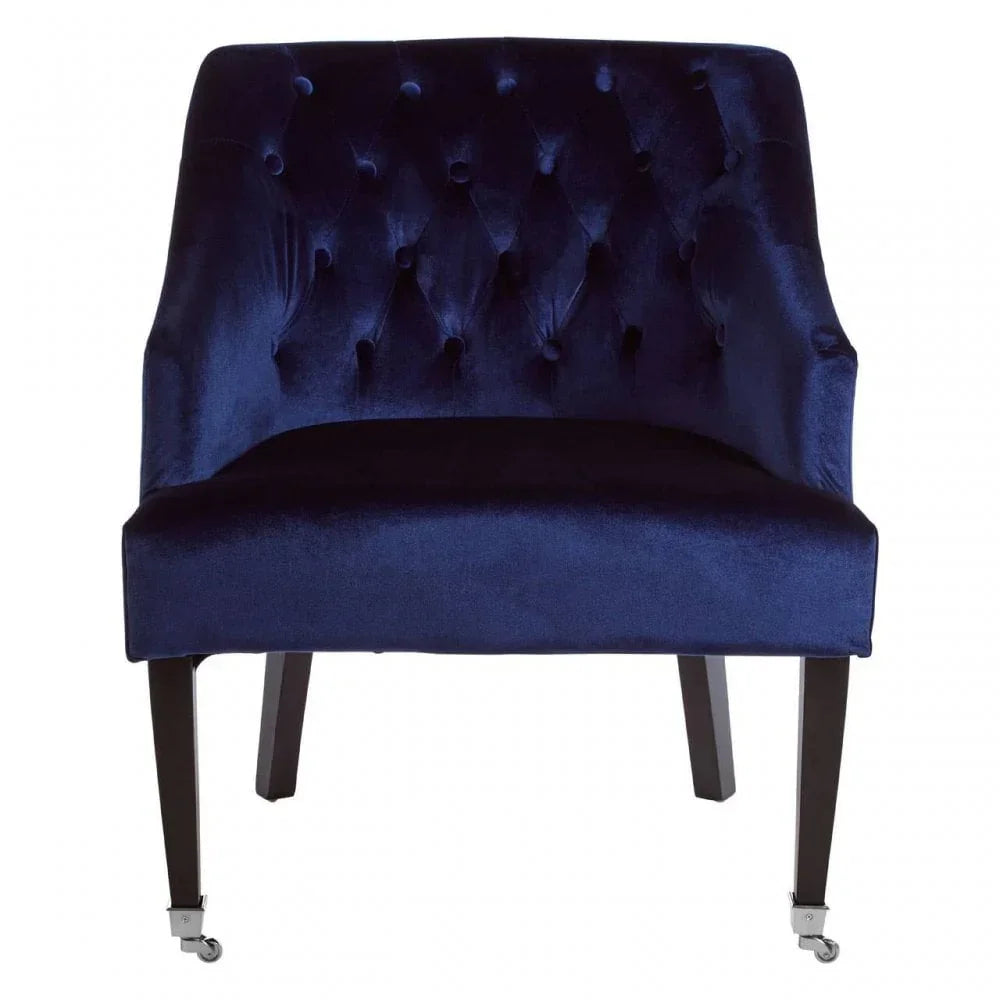 Navy blue velvet accent chair with tufted backrest and dark wooden legs on casters