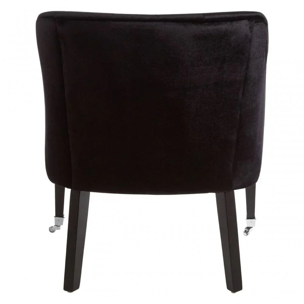 Black velvet accent chair rear view with wooden legs and silver castor wheels