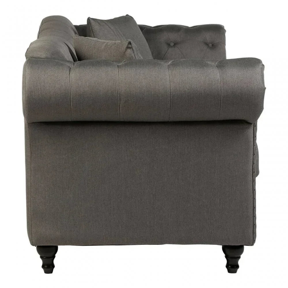 Side view of grey fabric sofa with button tufting and dark wooden legs