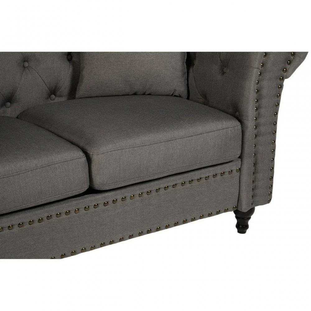 Grey fabric sofa with button tufted backrest and studded detail on front panel