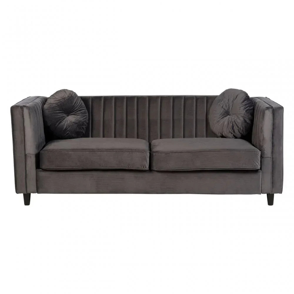 Charcoal velvet sofa with vertical panel detailing and two round scatter cushions