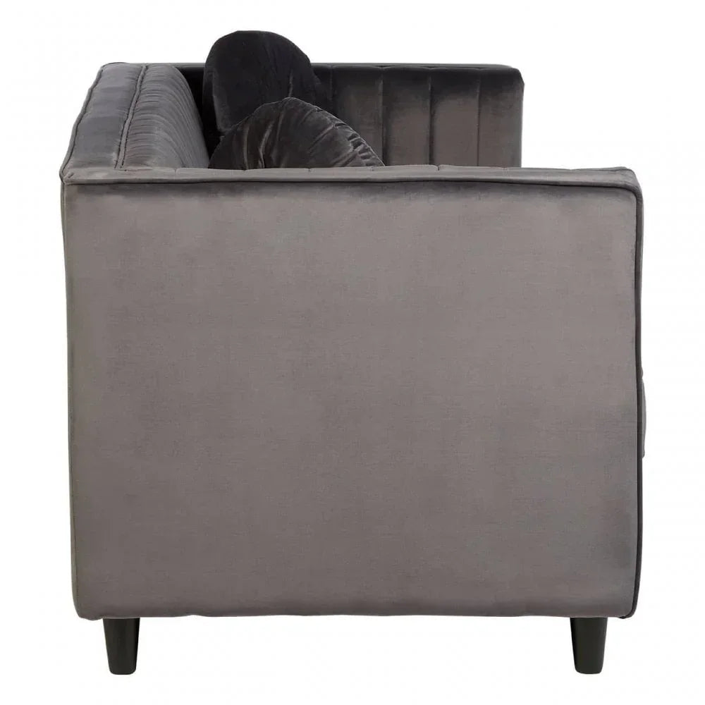 Side view of grey velvet sofa with black legs and vertical stitched backrest