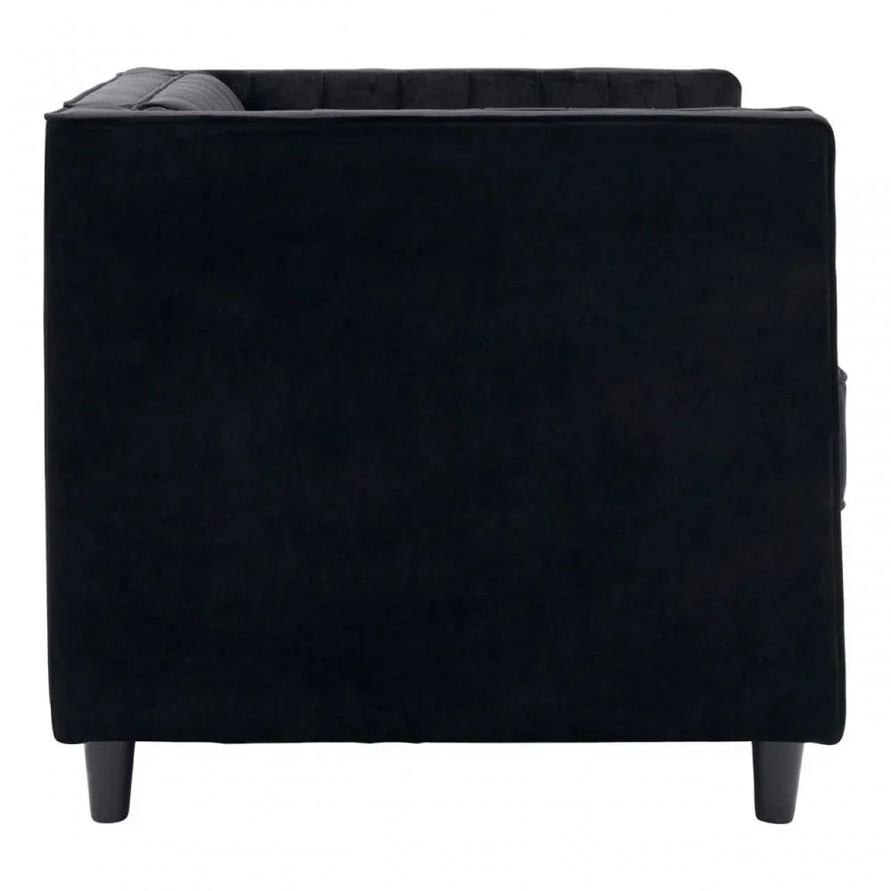 Side view of black velvet sofa with dark wooden legs and tufted cushion detail