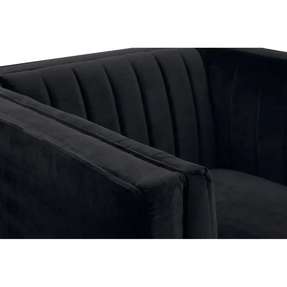 Close-up of black velvet armchair with vertical stitched upholstery detail