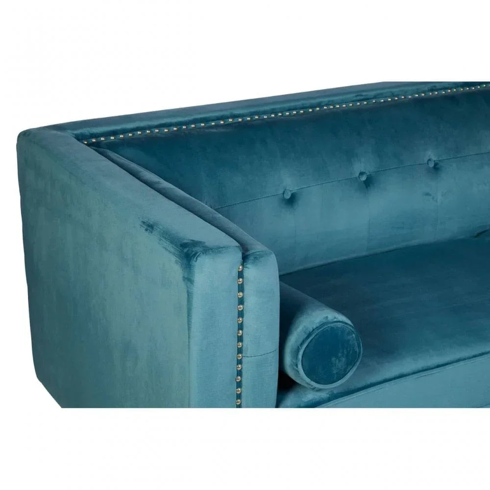 Teal velvet sofa with button back, studded trim, and cylindrical bolster cushion close-up