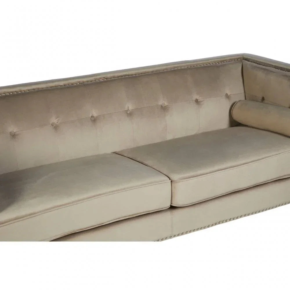 Beige velvet sofa with button-tufted backrest, nailhead trim and bolster pillow