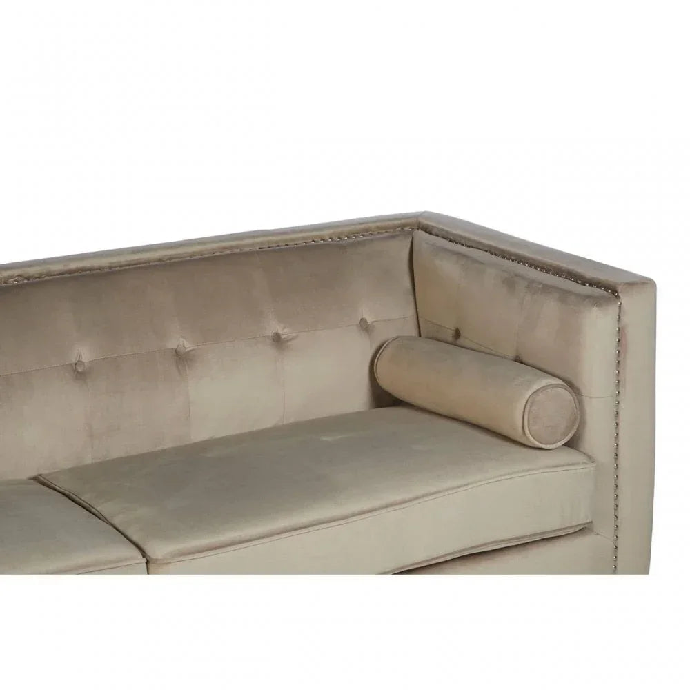 Beige velvet sofa corner with button-tufted backrest and matching bolster cushion