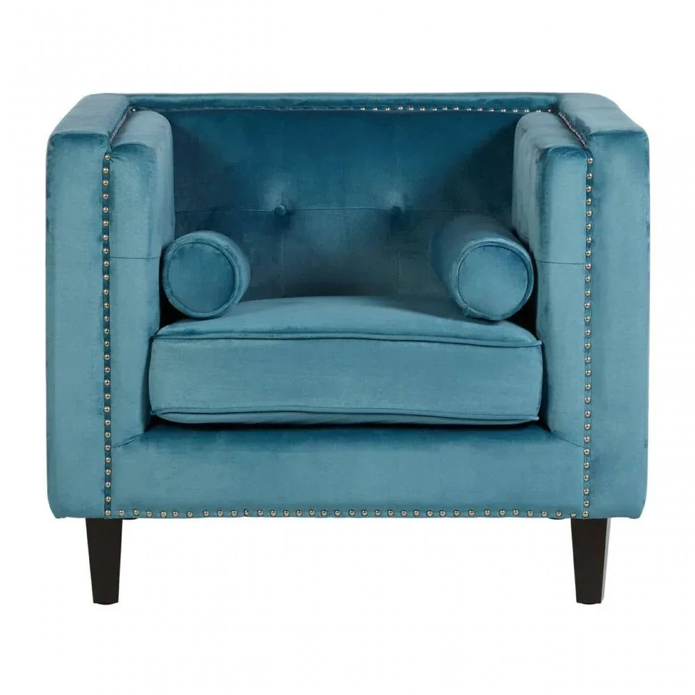 Blue velvet armchair with studded trim and cylindrical cushions, front view