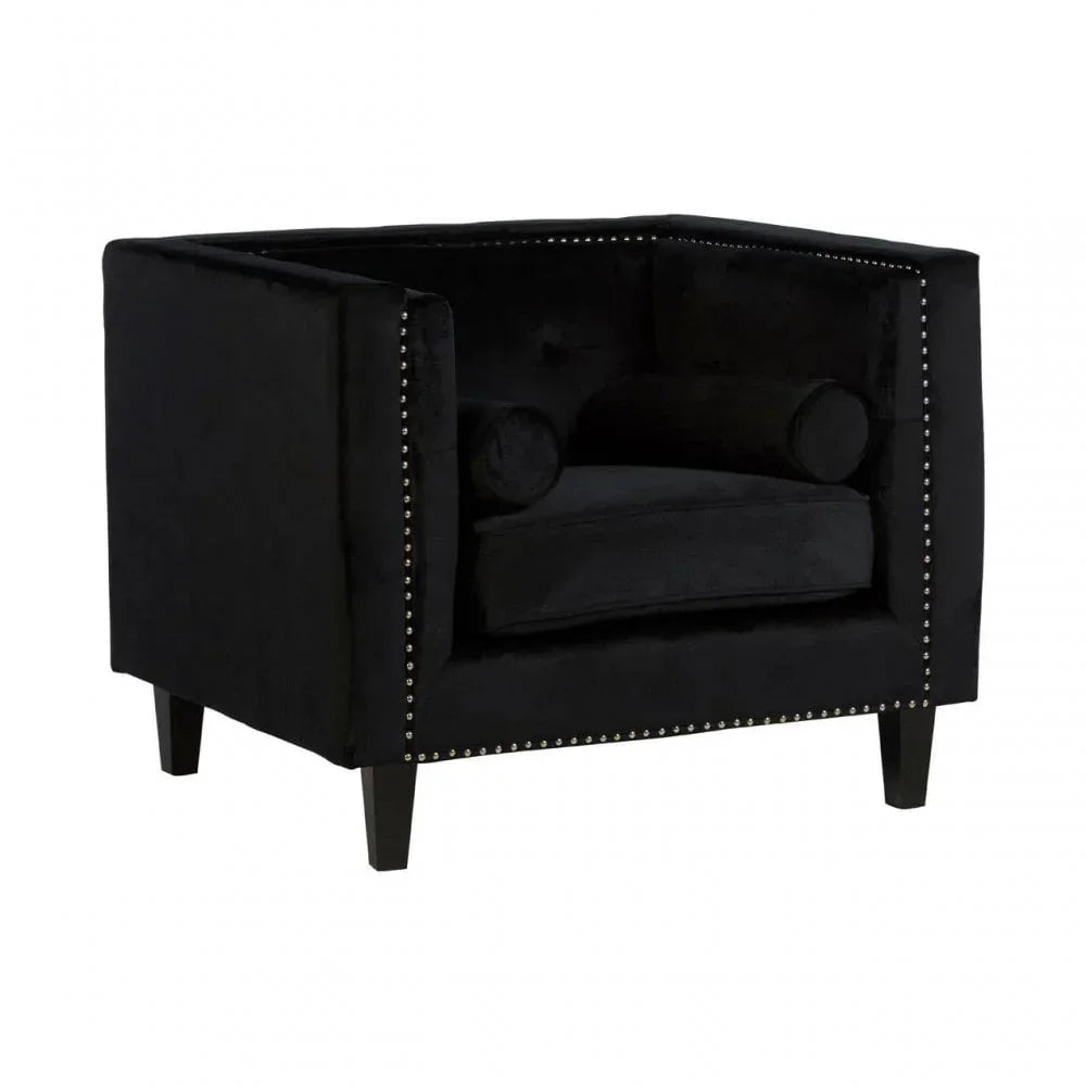 Black velvet armchair with silver stud detailing and two bolster cushions, front angle view