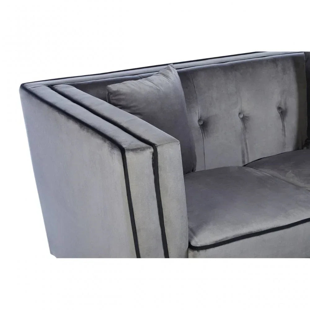 Grey velvet sofa with button tufted backrest and double armrest, close-up view