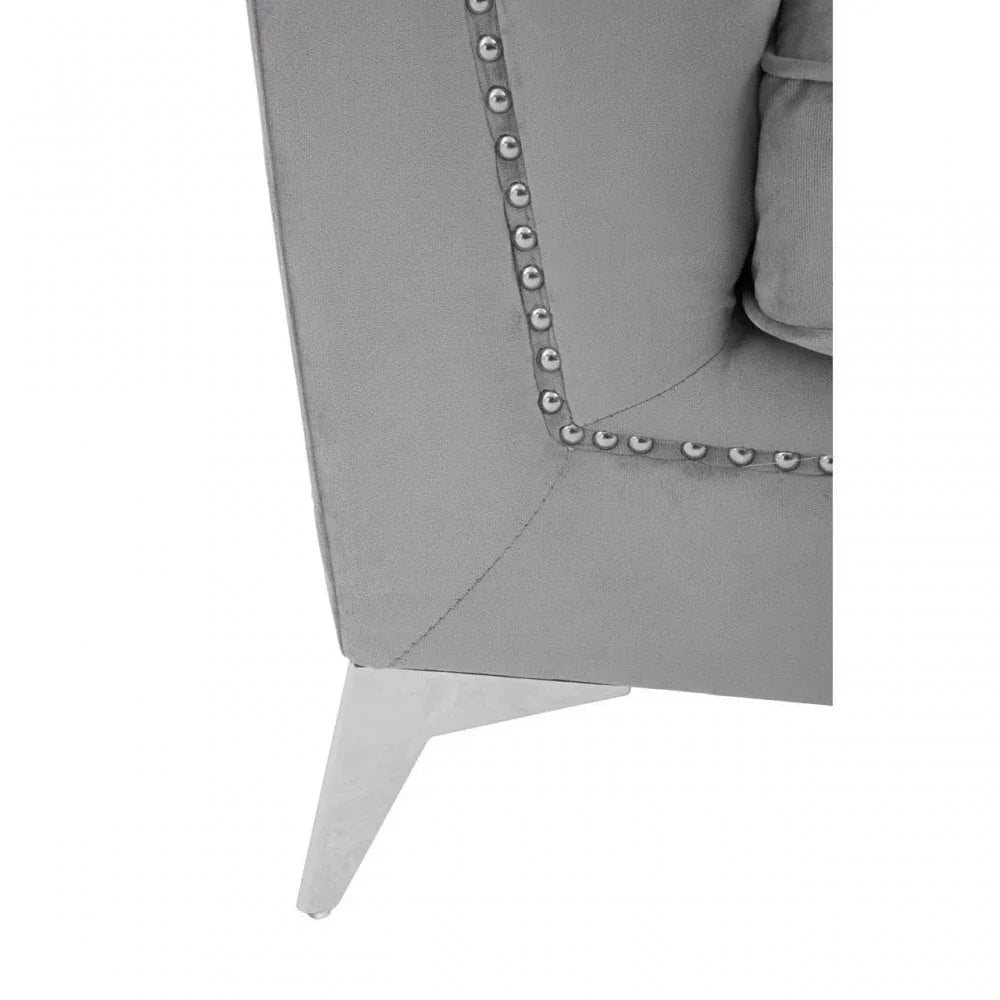Grey fabric sofa corner with metal stud trim and chrome leg