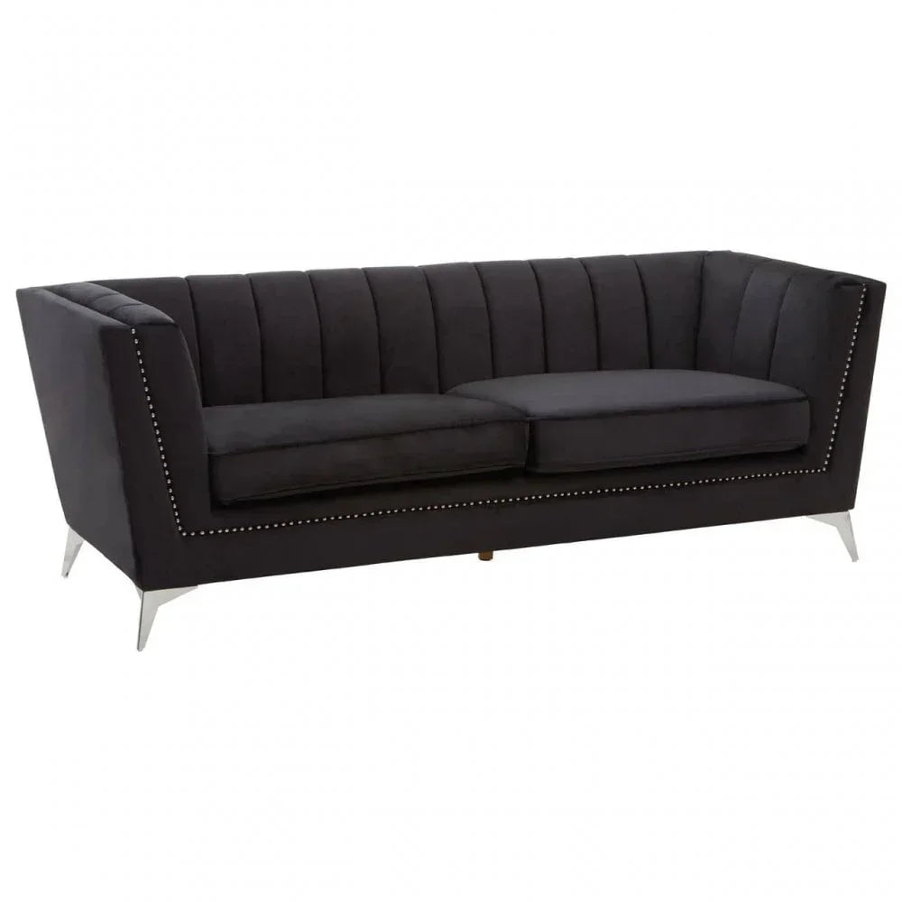 Black velvet sofa with metal legs, studded trim, and vertical channel tufting