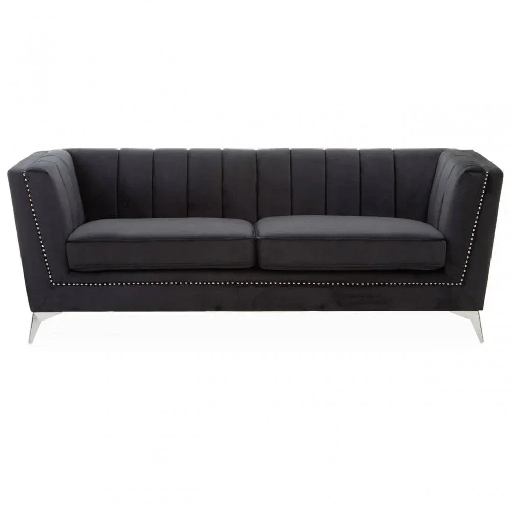 Black velvet sofa with vertical paneling, silver stud detailing, and metal legs