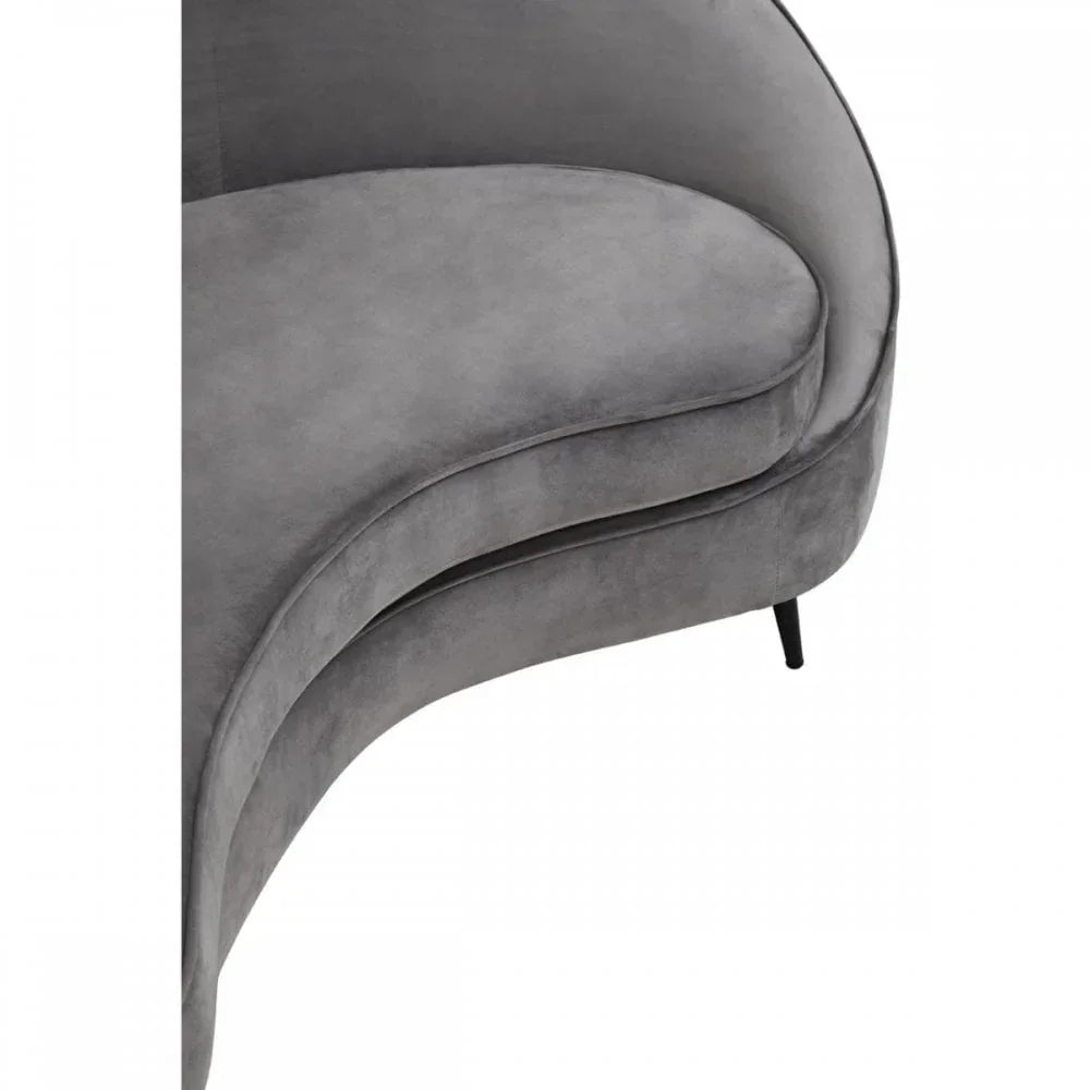 Curved grey velvet sofa seat with black metal legs, close-up of cushion and fabric texture
