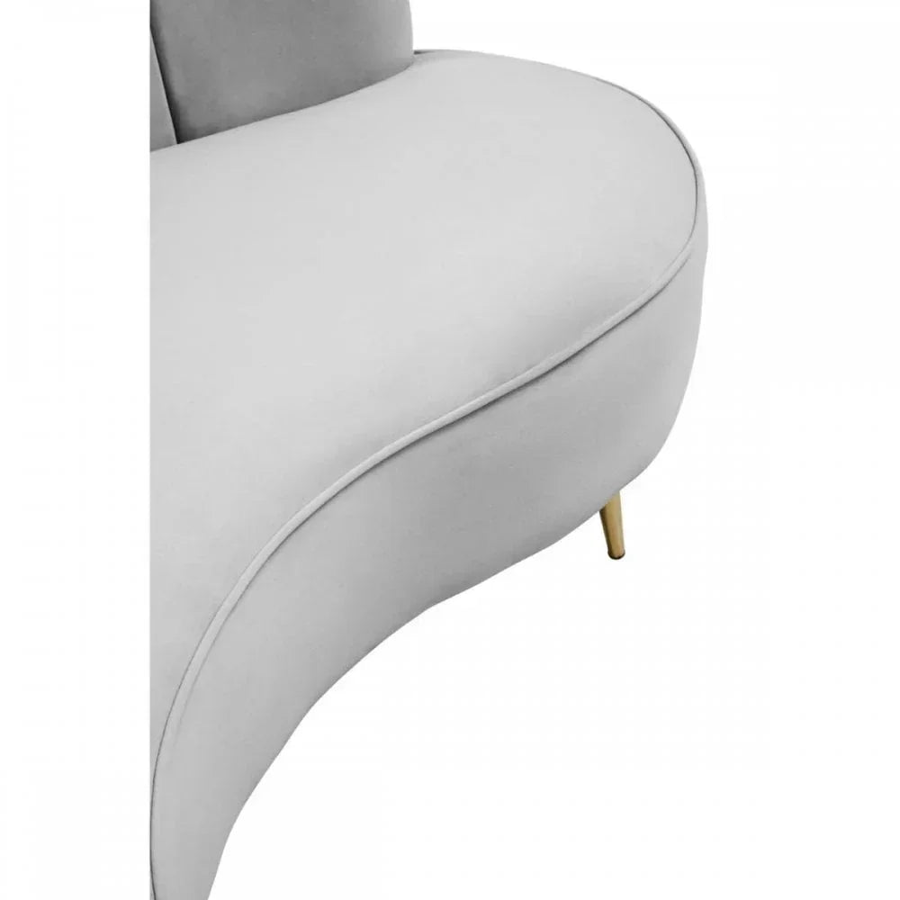Curved grey velvet sofa seat with gold metal leg, close-up on upholstery and corner
