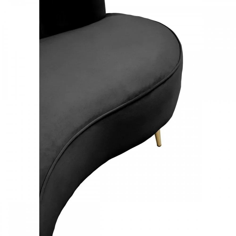 Curved black velvet chair seat with gold metal leg close-up