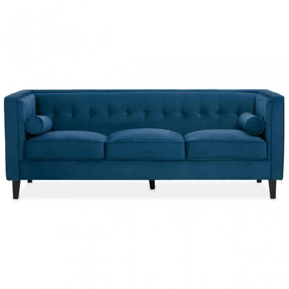 Navy blue velvet sofa with tufted backrest, three seat cushions, and cylindrical arm pillows