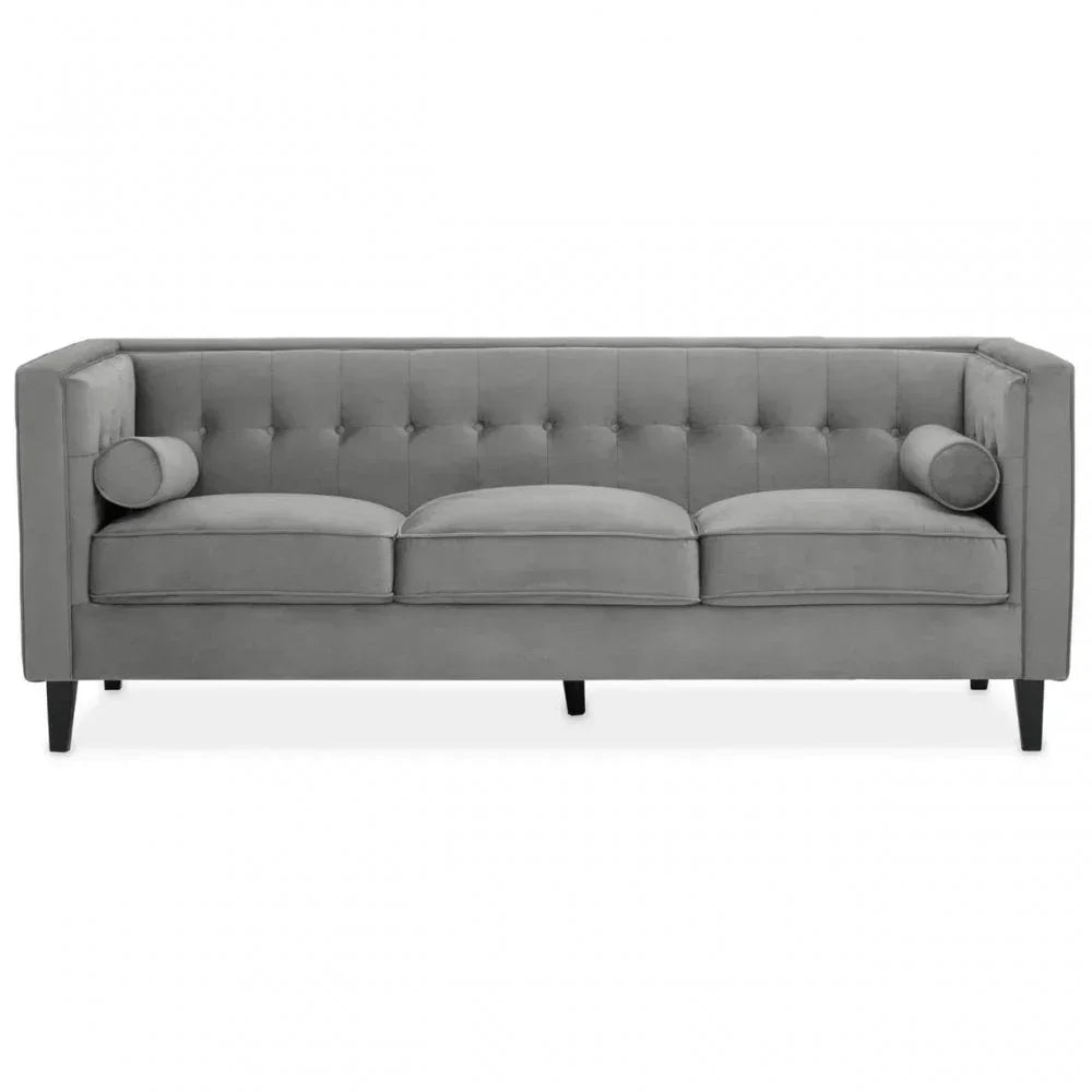 Grey velvet sofa with button-tufted back, three seat cushions and bolster cushions