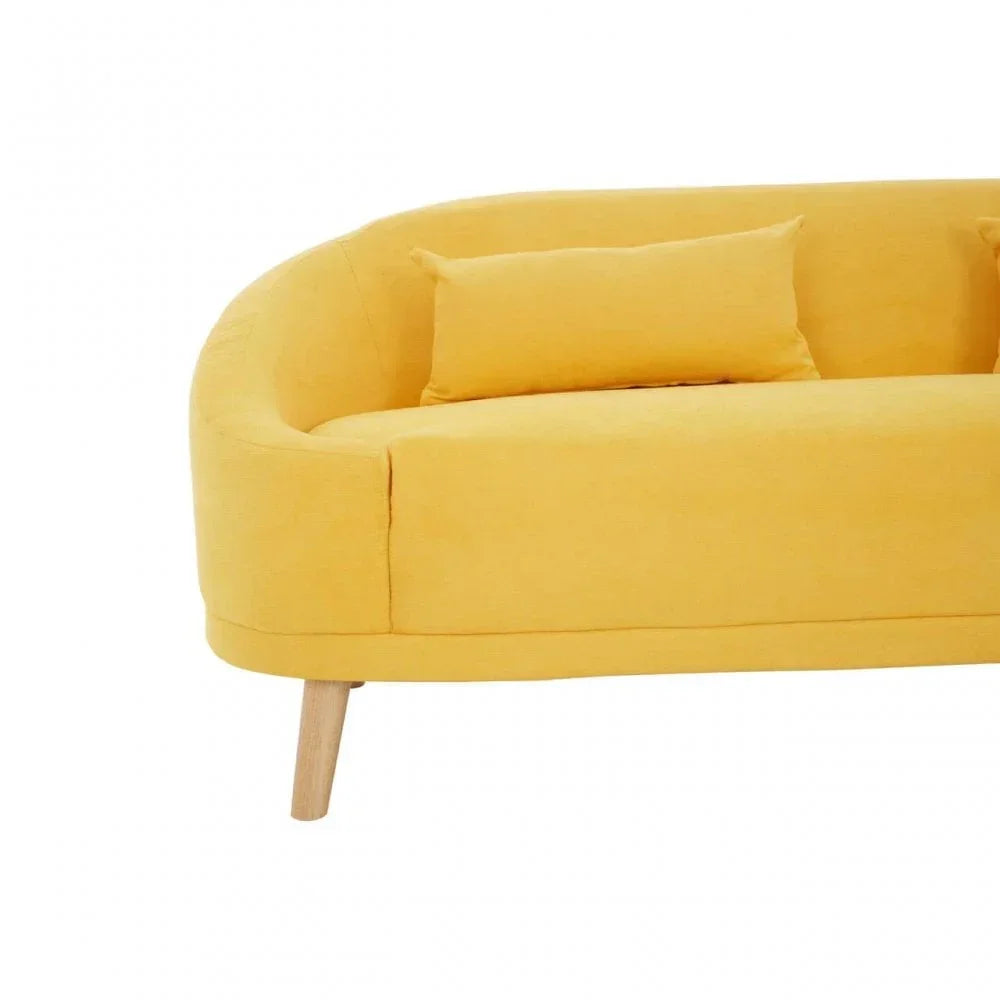 Yellow fabric sofa with curved back, wooden legs, and matching cushion