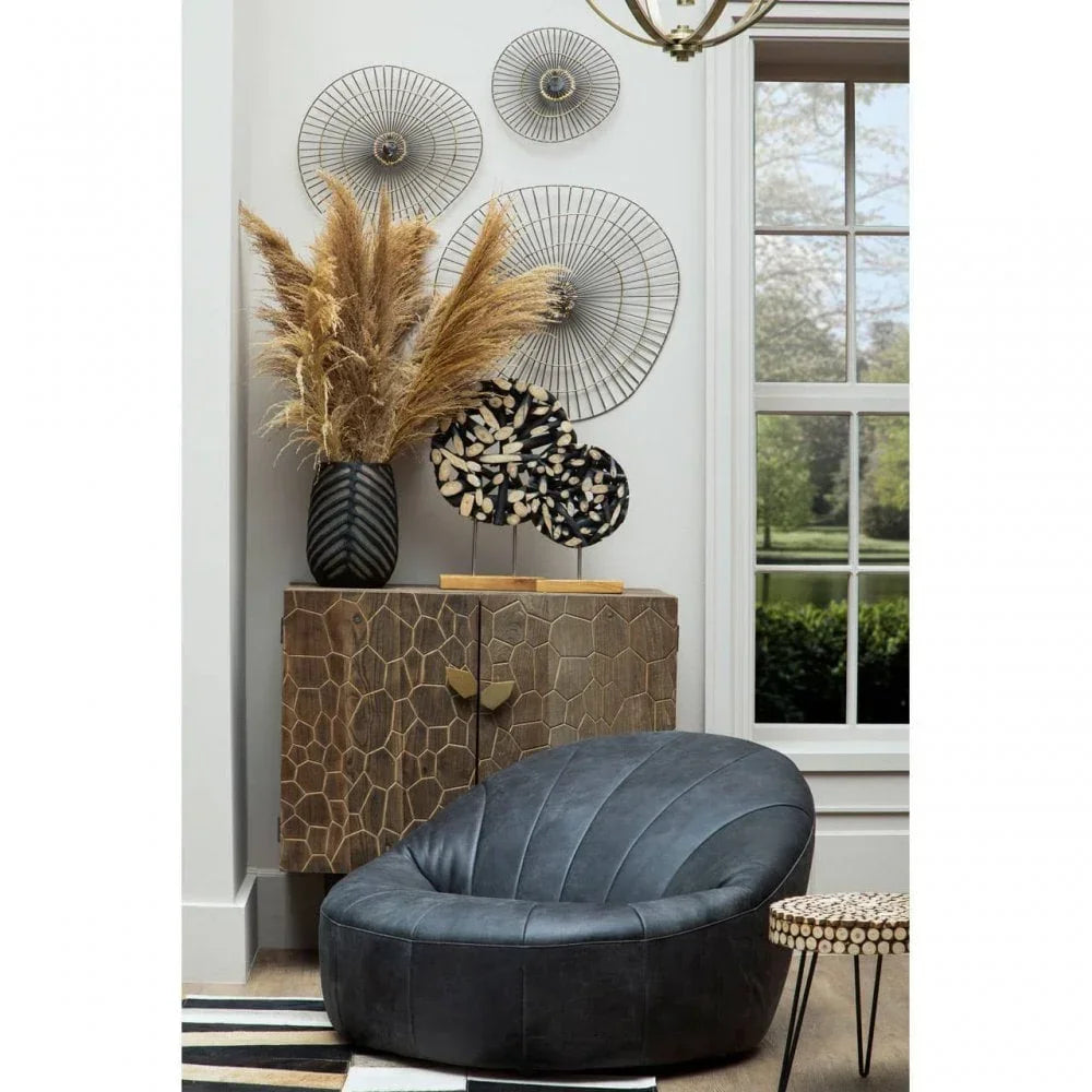 Modern grey accent chair in living room with geometric cabinet and decorative wall art