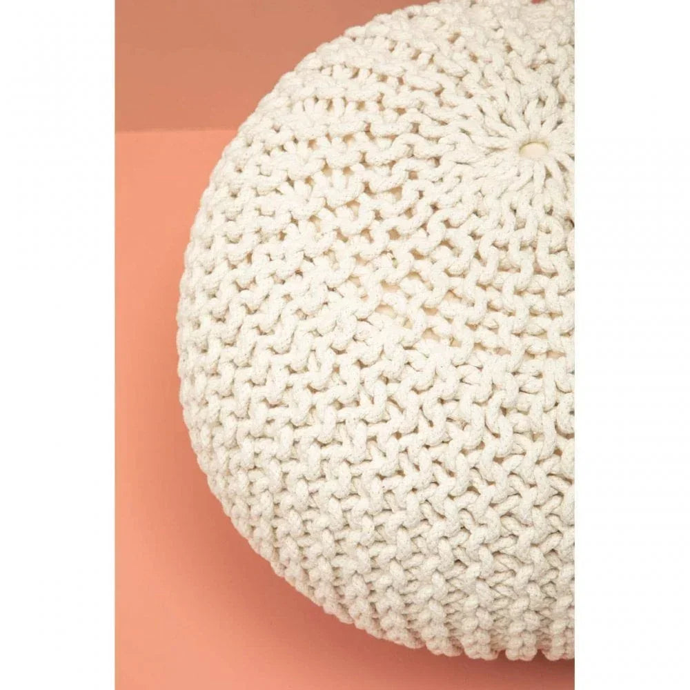 Ivory knitted pouffe closeup showing chunky textured pattern on peach background
