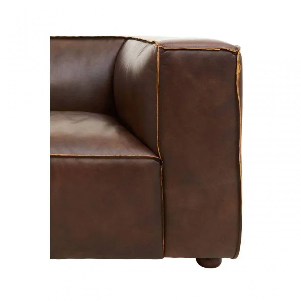 Close up of brown leather sofa armrest with visible stitching detail