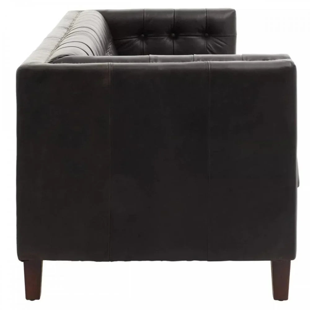 Side view of black leather sofa with tufted backrest and wooden legs