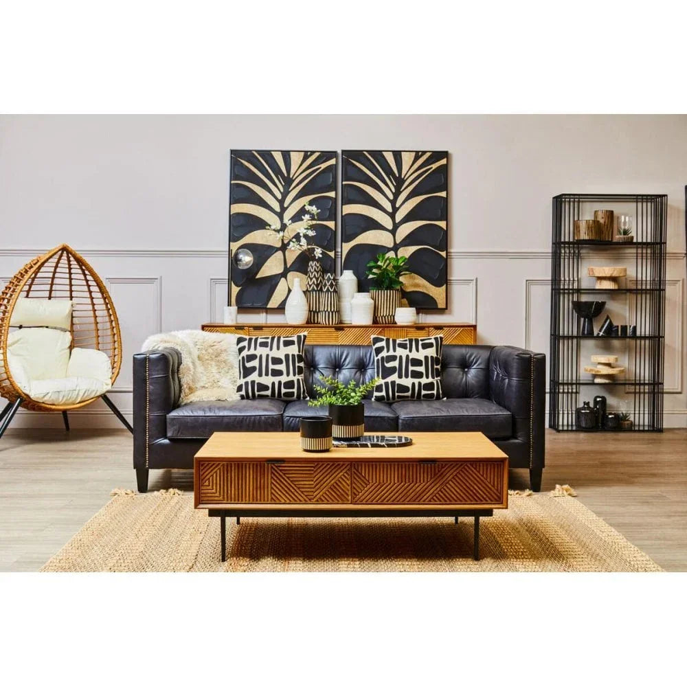 Modern living room with black leather sofa, rattan egg chair, wood coffee table, wall art