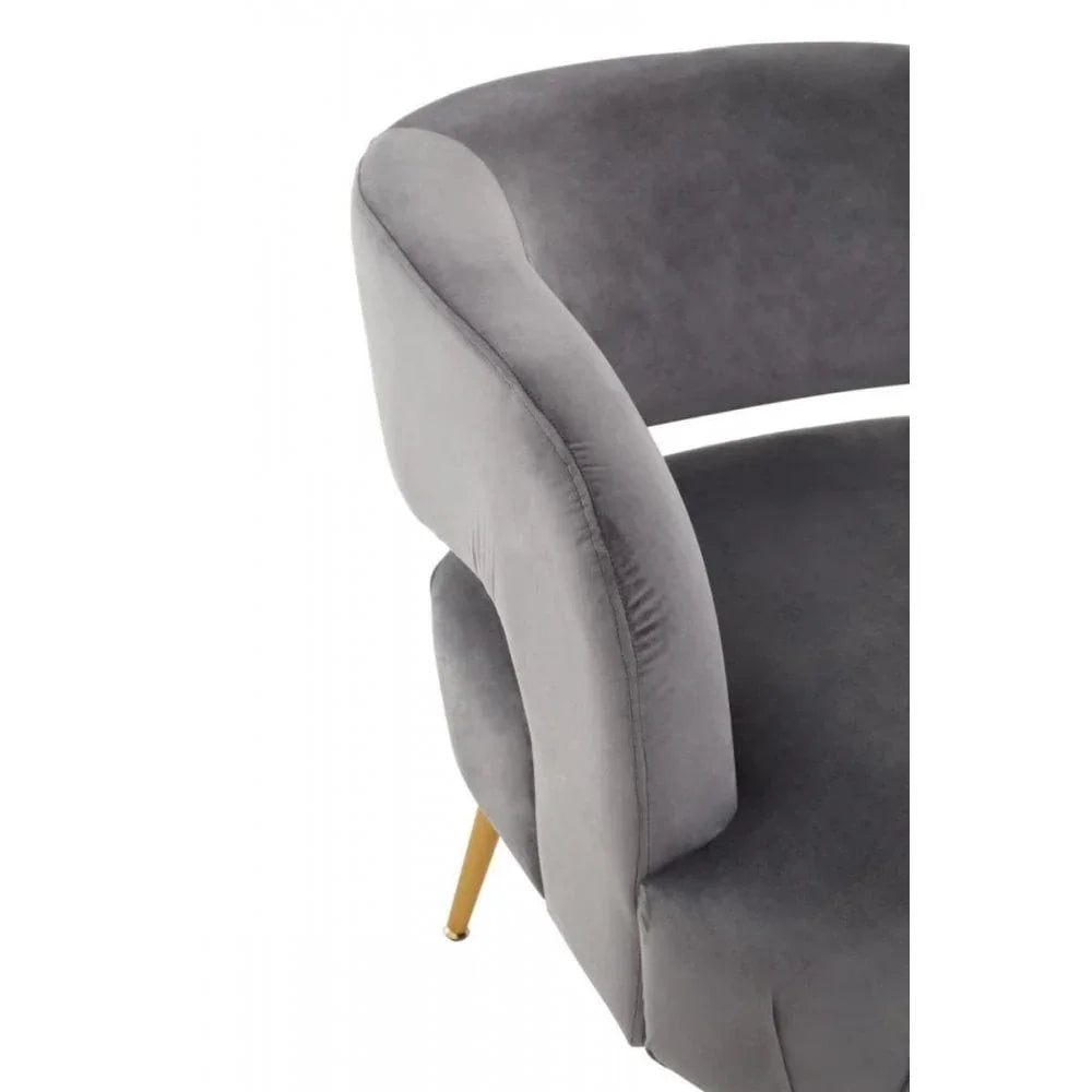 Curved grey velvet accent chair with gold metal legs, close-up of backrest and seat
