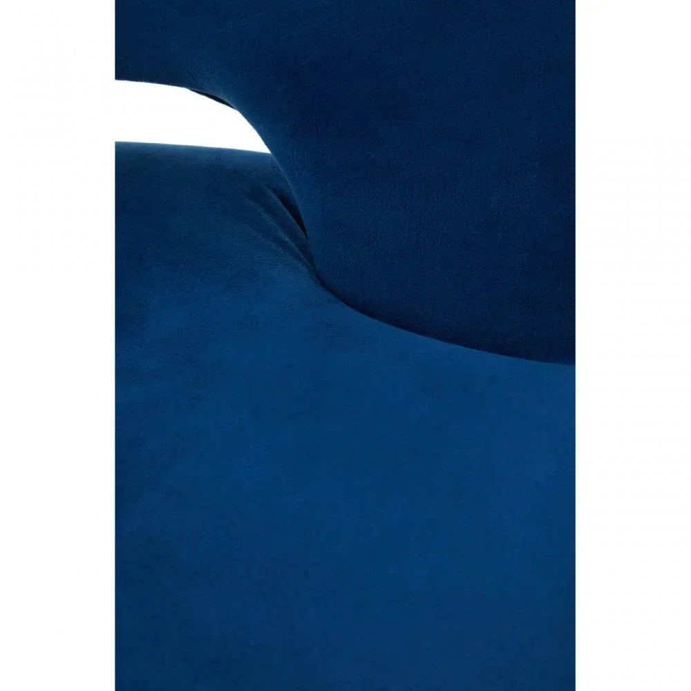 Close-up of blue velvet sofa upholstery with curved cushioning detail