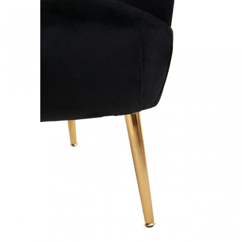 Black velvet chair corner with gold metal legs, close-up view