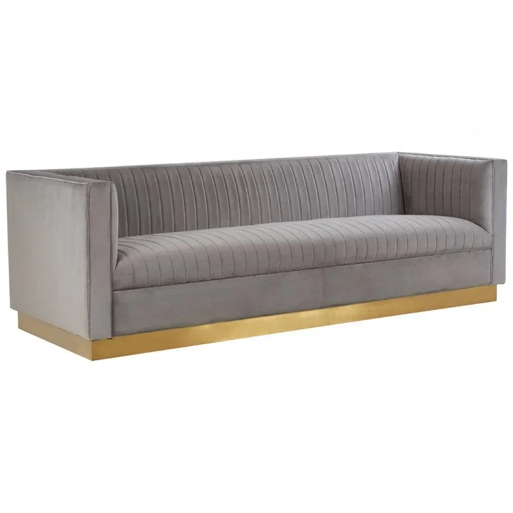 Grey velvet sofa with vertical channel tufting and gold base, front angle view