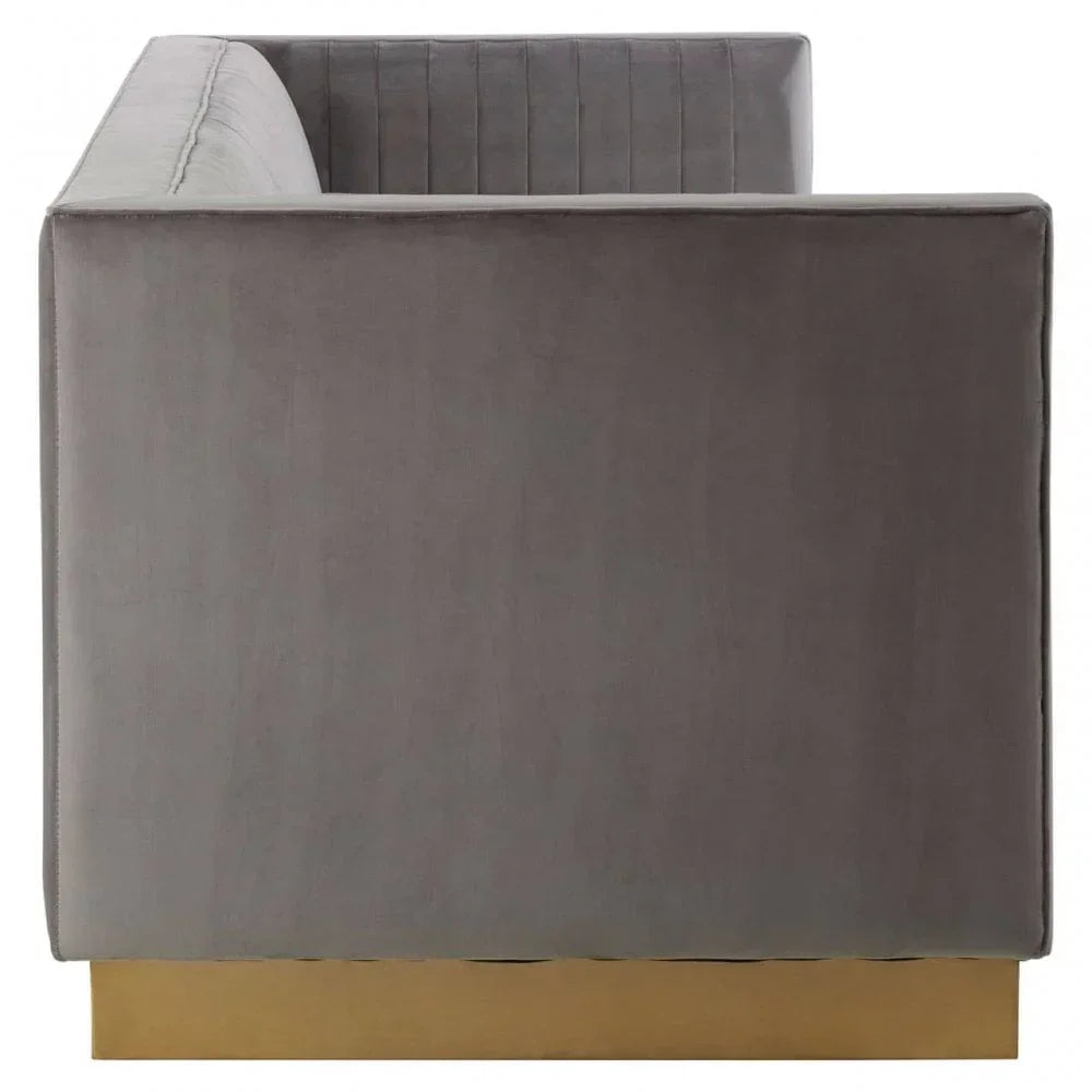 Side view of grey velvet sofa with gold metal base and vertical stitched backrest
