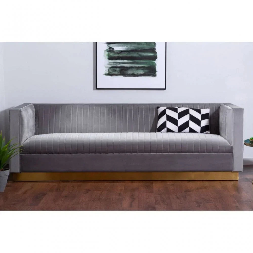 Grey velvet sofa with gold base and black and white cushion in modern living room