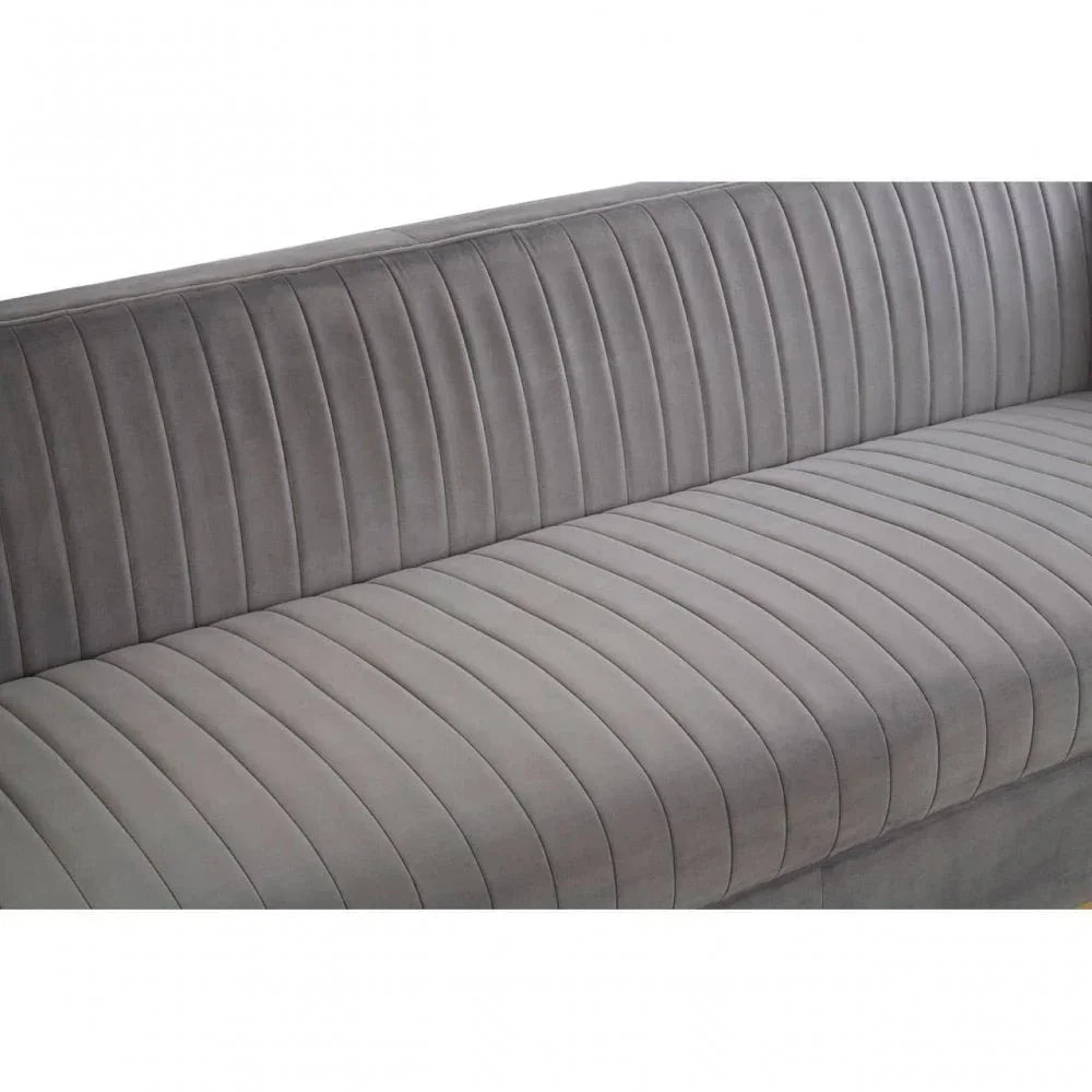Grey velvet sofa with vertical channel tufting on backrest and seat, close-up angle