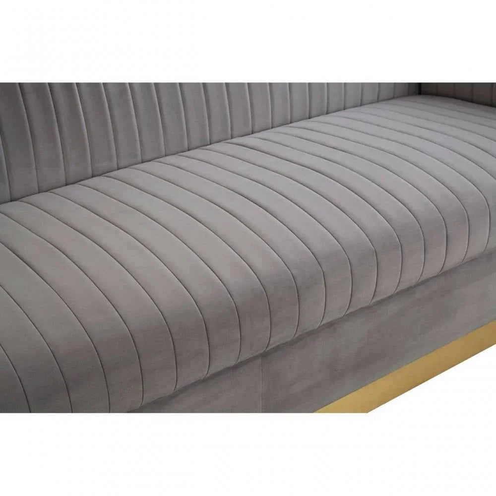 Closeup of grey velvet sofa seat with vertical stitching and gold base