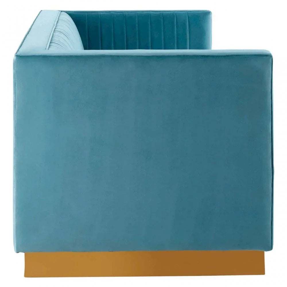 Side view of blue velvet sofa with vertical stitched back and gold base