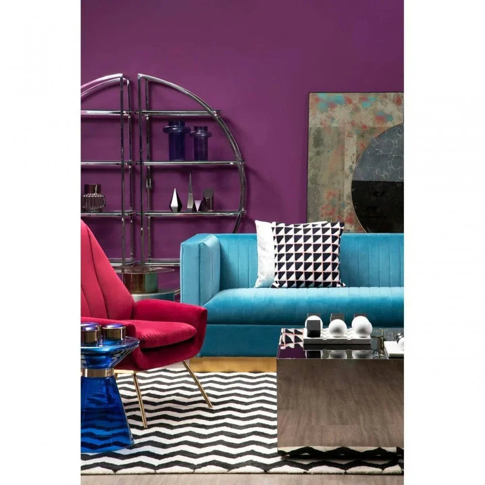 Blue velvet sofa and pink armchair with geometric cushions in modern living room