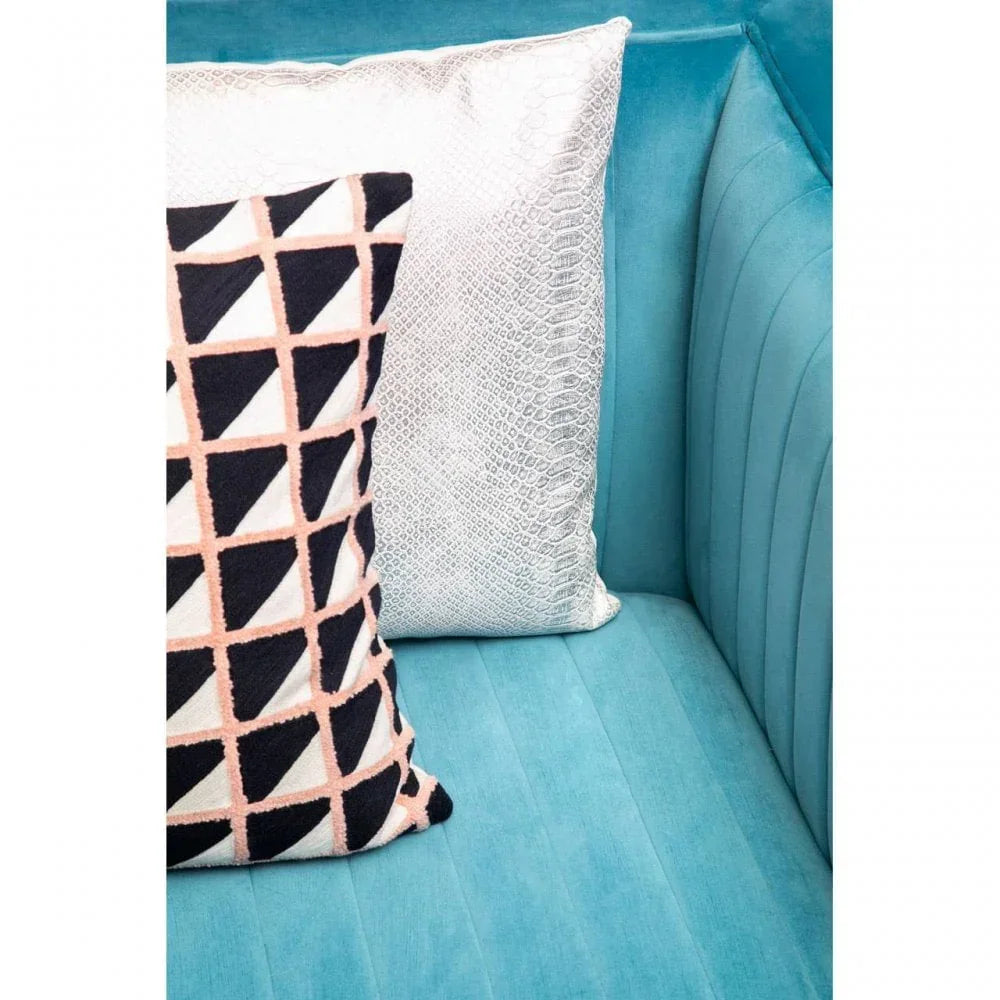 Blue velvet sofa corner with geometric cushion and metallic textured cushion