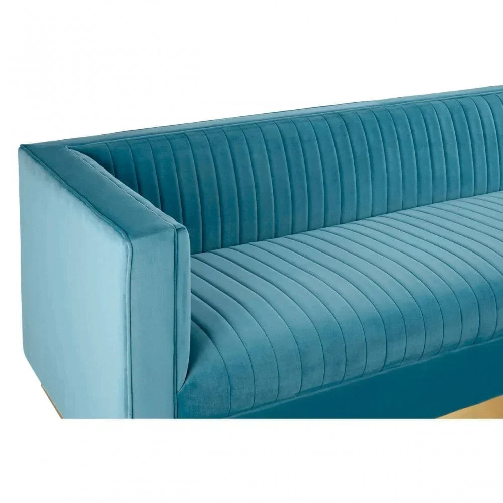 Blue velvet sofa with vertical channel tufting and square armrest, close side angle view