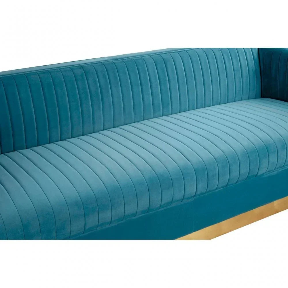 Teal velvet sofa with vertical channel tufting and gold base detail, close-up view